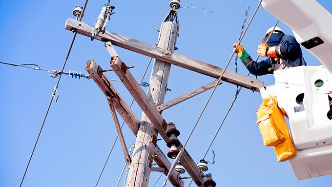 Pessoa trabalhando em linhas elétricas